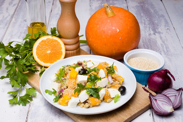 Vegetarian quinoa salad with pumpkin, olives, raisins, red onions and mozzarella cheese.
