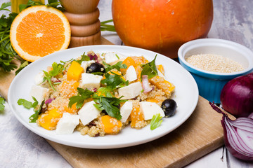 Vegetarian quinoa salad with pumpkin, olives, raisins, red onions and mozzarella cheese.