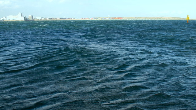 Sunshine reflections and strong winds over the ocean waves.