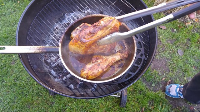 Turn turkey meat with barbecue tongs
