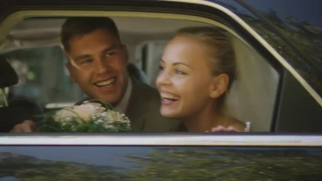 Newlyweds arrive in a black car and kiss. Shot on RED Cinema Camera.