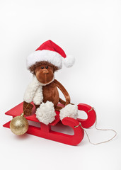 A toy monkey in a sleigh on a white background