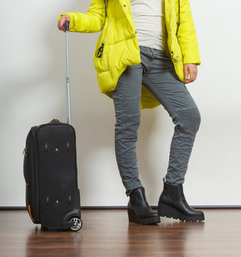 Woman in warm jacket with suitcase.