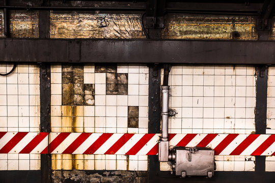Grunge subway wall backdrop with broken tiles and caution lines