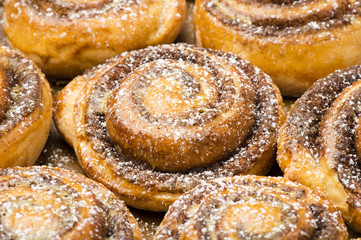 Homemade cinnamon buns as background.