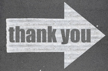 Arrow on asphalt road written word thank you