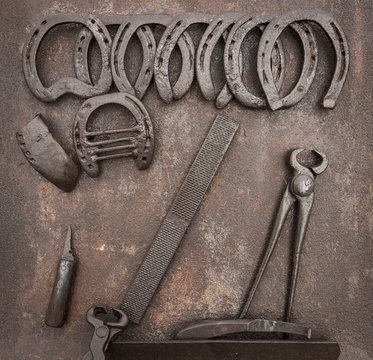 old Horse Shoeing Kit on a rusty metallic background
