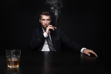 Geschäftsführer entspannt bei Drink und Zigarre 