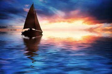 Yacht sailing against sunset