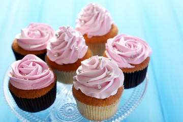 Tasty cupcakes on color wooden background