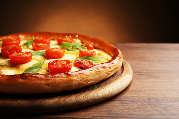 Pizza Margherita with arugula on brown background