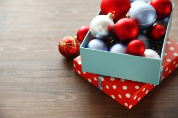 Box with Christmas toys on wooden background