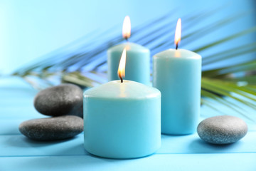 Fototapeta na wymiar Spa composition of blue candles, stones on blue background