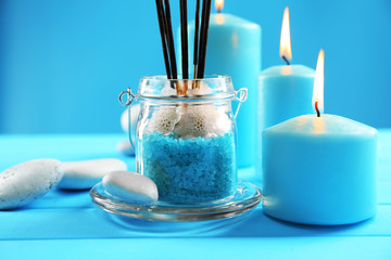 Spa composition of blue candles, stones and sea salt on blue background