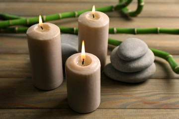 Fototapeta na wymiar Spa composition of candles, stones and bamboo on wooden background