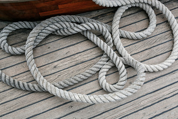Obraz premium Coiled rope on a wooden deck