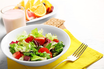 Tasty oatmeal and vegetable salad on wooden background. Healthy eating concept.