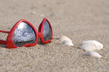 Heart Shaped Red Sunglasses in Sand with Seashells