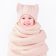 happy kid, boy covered in volume knitted scarf and hat