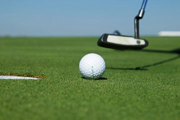 Golf club and ball in grass