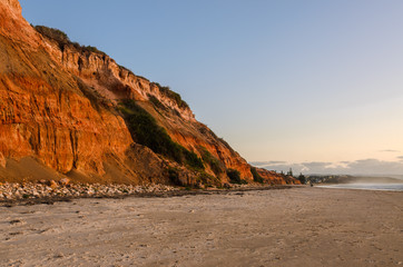 Cliffs coast line sand beach landscape at sunset