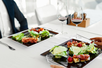 Healthy Food. Couple Eating Caesar Salad For Meal In Restaurant.