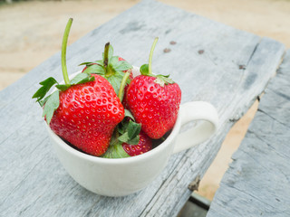 strawberries in a cup on the wooden table