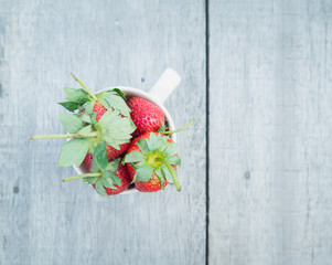 strawberries in a cup on the wooden table