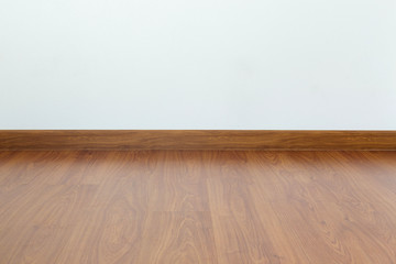 empty room with brown wood laminate floor and white mortar wall