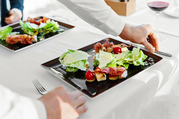 Healthy Food Eating. Closeup Of Young Couple Having Caesar Salad With Roast Chicken, Vegetables And Cheese For Meal In Luxury Gourmet Restaurant. People On Date. Romantic Dinner Or Lunch, Diet Concept
