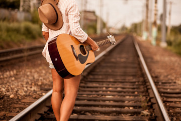 Girl walking on railway wish guitar