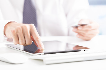 Man holding credit card in hand and entering security code using