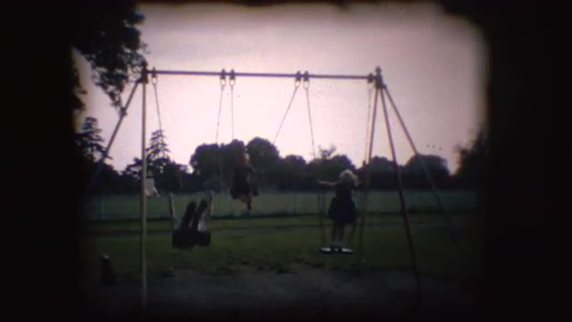 Vintage 8mm footage of children playing on a swing in England