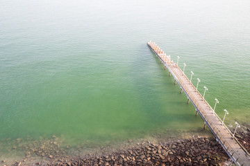 Jetty on the coast reaches out to calm green sea