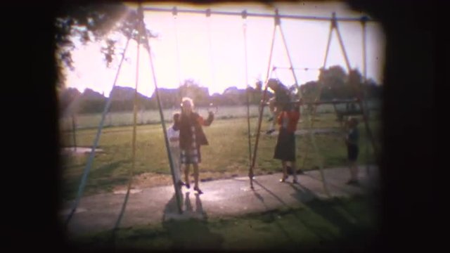 Vintage 8mm footage of children playing on a swing in England