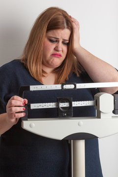 Worried woman on a medical weight scale