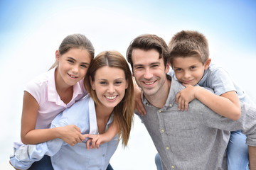 Parents giving piggyback ride to kids outside