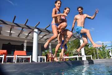 Family jumping into pool swimming-pool
