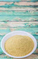 Dried bakers yeast in white bowl over wooden background