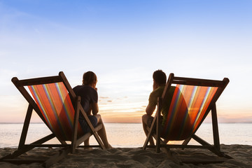 Couple sitting in deckchairs on the beach thinking about life