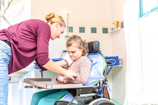 Disability a disabled child being cared for together with a nurse using special needs equipment / Disability a disabled child being cared for