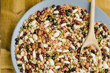 legumes in a dish on wood, close up, background.