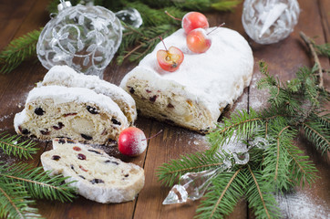 Christmas Stollen with raisins, candied fruit and marzipan on a wooden table