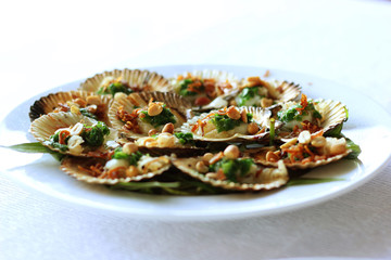 Seared scallops in the shell scallops with nuts.