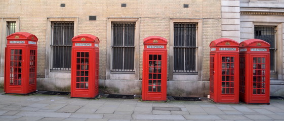 Traditional British red telephone boxes in a row - Powered by Adobe