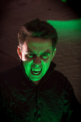 Vampire in his lair illuminated by ghoulish green light 