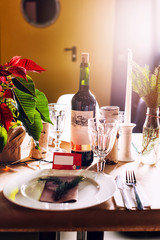 Decorated Christmas holiday table ready for dinner. Beautifully decorated table set with candles, spruce twigs, plates and serviettes for event in the restaurant.