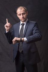 Portrait of young man in tie looking at his watch