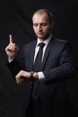 Portrait of young man in tie looking at his watch