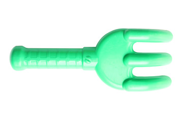green children's plastic rake on a white background isolated